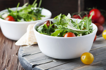Healthy salad with rocket, tomato and parmesan cheese