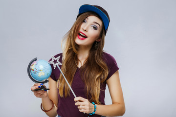 Young girl with little globe at gray background