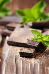 Dark chocolate and green mint on the wooden table