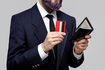 Serious businessman posing with wallet and credit card