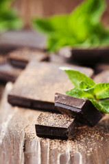 Dark chocolate and green mint on the wooden table
