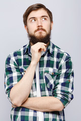 Cheerful young man, posing with hand touching his beard