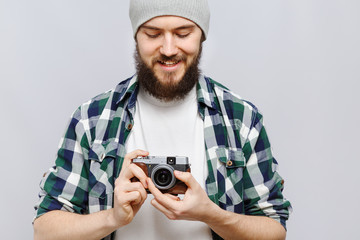 Smiling young man holding retro camera on his hand