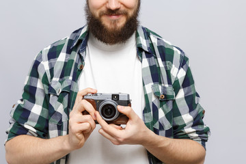 Young happy hipster holding retro camera on his hands