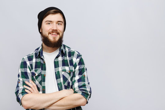 Cheerful bearded hipster posing on white background