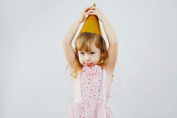 Funny girl touching tip of her hat in studio