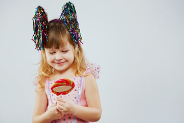 Lovely girl, looking on colorful candy in her hands