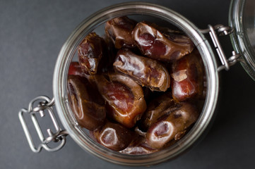 A lot of dates in a glass jar, view from above