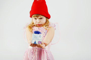 Dissatisfied little girl looking on little present in her hands