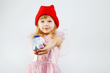Charming little girl holding little present in studio