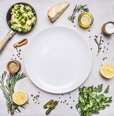 Healthy vegetarian foods, broccoli sprouts in a small frying pan, oil and seasonings, herbs and lemon place for text,frame on wooden rustic background top view