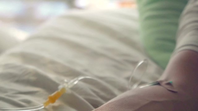 Hand of a patient with pulse meter lying with drop counter on the bed. Doctor fills medicine dropper syringe. 4k