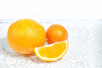 Fototapeta na wymiar orange fruit in section in white water