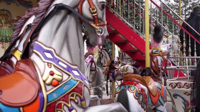 Father and daughter finished a ride on merry-go-round carousel, happy childhood
