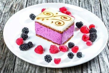 a piece of cake souffle with blackberries, raspberries, closeup