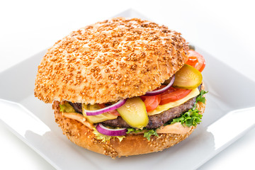 Delicious original american hamburger with grilled beef and vegetables on white plate, snack or lunch, product photography for restaurant or bistro