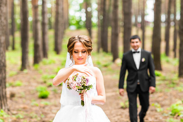 Groom and Bride in a park. Bridal wedding bouquet of flowers