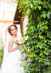 Beautiful bride girl in wedding dress  and bouquet of flowers, outdoors portrait