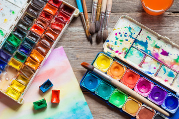 Set of watercolor paints, brushes for painting and paper sheet 