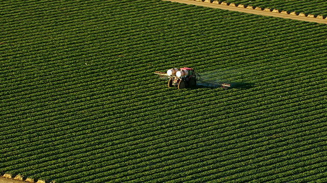 Aerial shot of tractor spraying field
