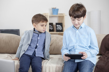 Little boys manages work from home via tablet, Happy Little businessmans