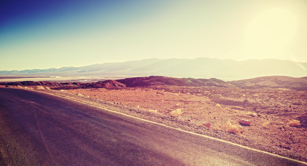 Fototapeta premium Vintage toned sunset over desert road, travel background