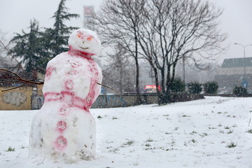 Funny white red snowman in the park with cap made of cardboard
