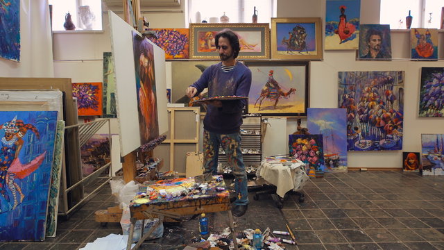 senior man painting on a canvas