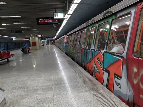Bucharest, Romania, March 13, 2016: Passengers are traveling old trains of metro, covered by graffiti, in one of the newest line.