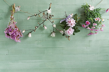 sfondo primavera con fiori appesi e legno verde pastello