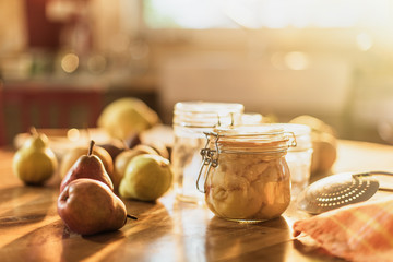 homemade rustic jar of fruits with pears on wooden table - blur
