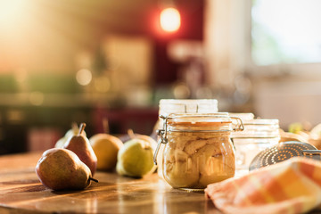 homemade rustic jar of fruits with pears on wooden table - blur