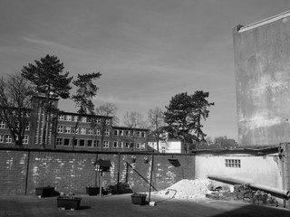 Hinterhof mit alter Backsteinmauer und Baumaterial im Sonnenschein in einem Arbeiterviertel im Stadtteil Schildesche in Bielefeld im Teutoburger Wald in Ostwestfalen-Lippe, fotografiert in Schwarzweiß