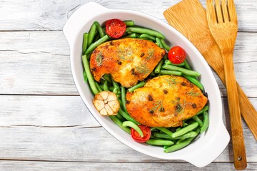 baked chicken breasts with green beans and tomatoes, top view