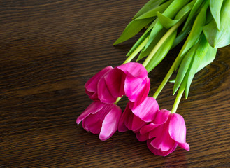 Fototapeta na wymiar Pink tulips on brown background