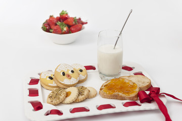 Close up of tray with homemade jam, chick cookies and milk
