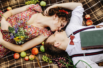 beautiful happy bride and stylish retro groom lying on tweed bla