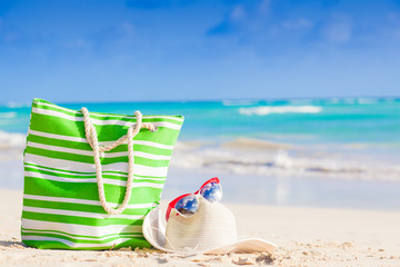 beach bag, sunglasses and straw hat on tropical beach