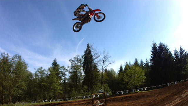 Motocross racer soars over large jump, slow motion