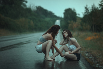 Women quarrel in  rain on the road.
