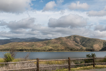 Fototapeta na wymiar A mountain range and lake on a cloudy day at Otay Lakes County Park in Chula Vista, California.