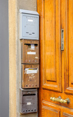 Typical french postal boxes near wooden door with vintage handle in the city of Marseille, France