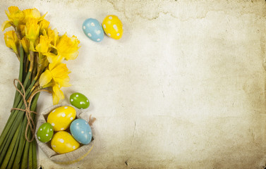 Easter background with painted eggs and blooming daffodils