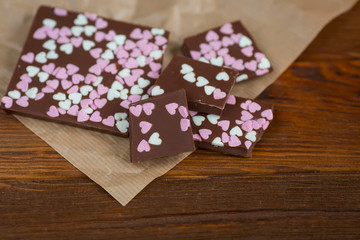 chocolate bar with hearts on a wooden background