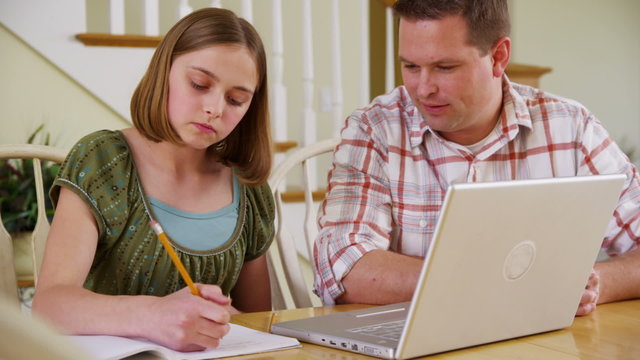 Father helping daughter with homework