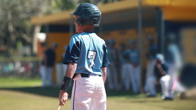 Slow motion of batter getting ready to bat during baseball game. 