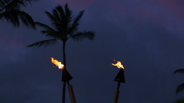 Two tiki torch flames blowing in the wind at night on Maui, Hawaii.