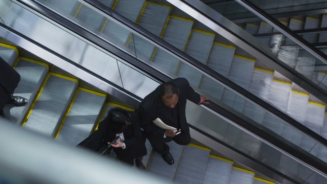 Business people on escalator, overhead view
