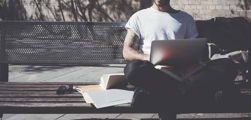 Photo man sitting city park and texting message notebook. Studying at the University, working...