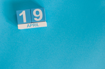 April 19th. Image of april 19 wooden color calendar on blue background.  Spring day, empty space for text. The Day Of Snowdrop